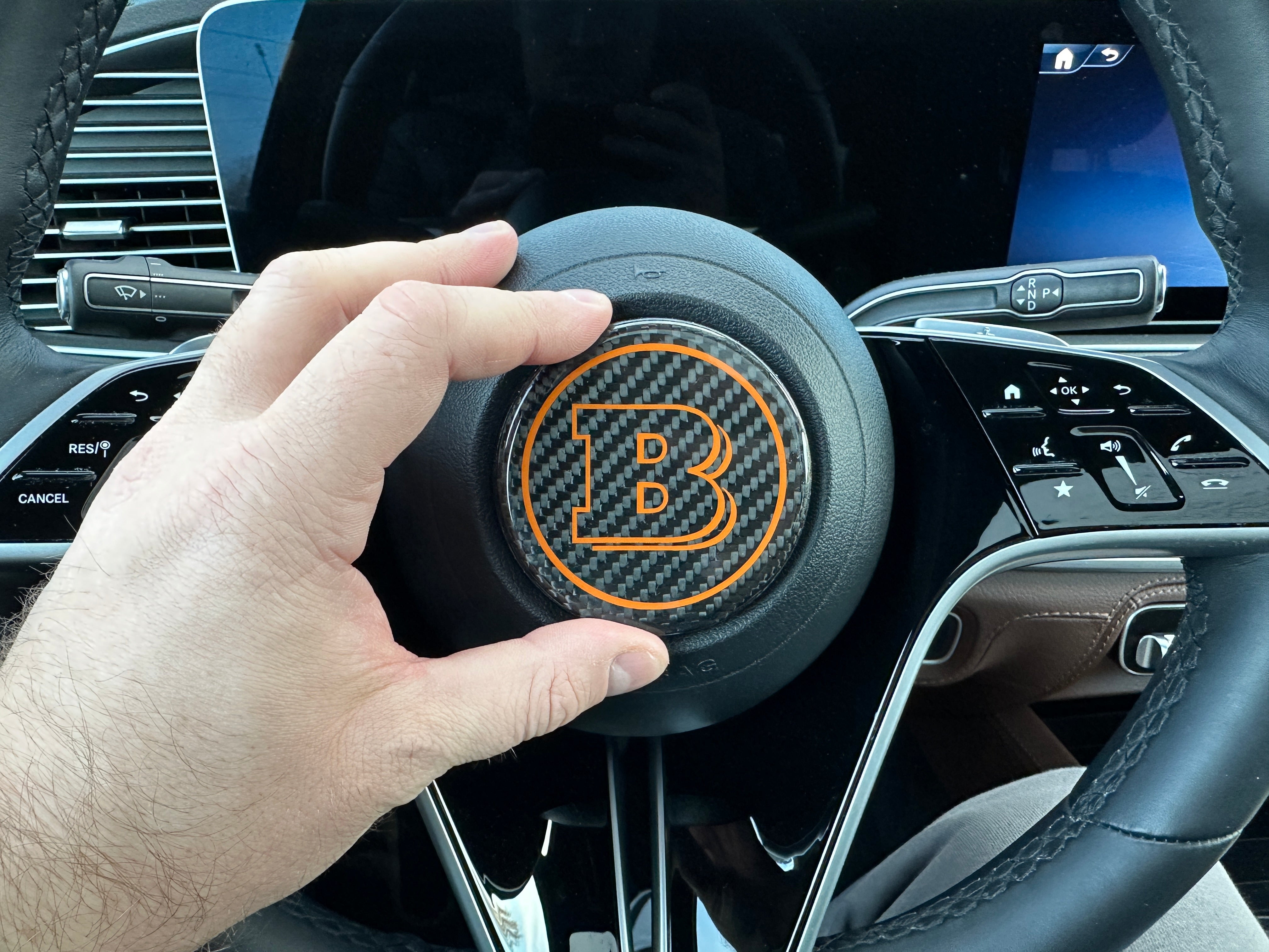 Brabus carbon fiber badge for new Mercedes-Benz steering wheels (2021+), available in multiple colors for a personalized luxury upgrade.