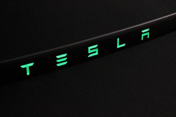 Carbon rear trunk trim with LEDs for Tesla Model S from Custom Class, made of genuine carbon fiber with a grey gloss UV-resistant coating.