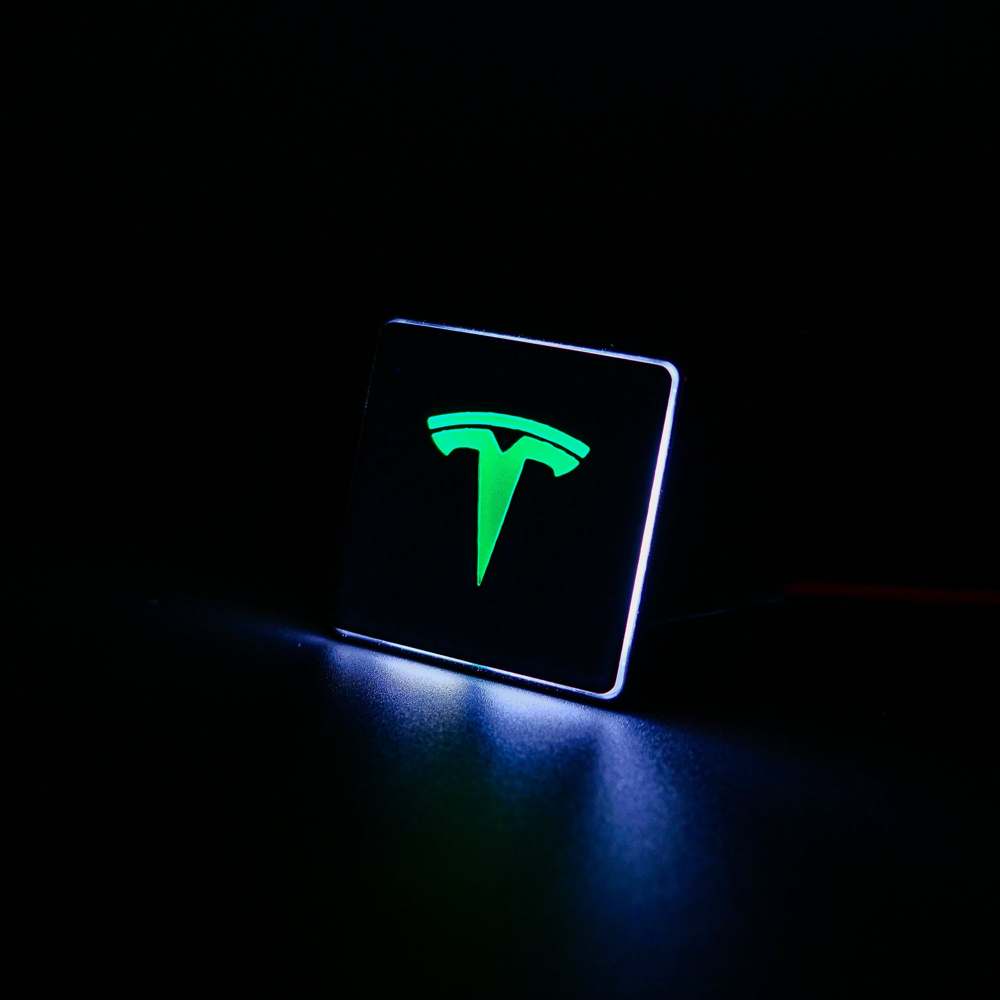 Carbon metal LED-illuminated seat emblems for Tesla Model S, Model 3, Model X, Model Y, and Cybertruck, available in customizable LED colors for front and rear seats.