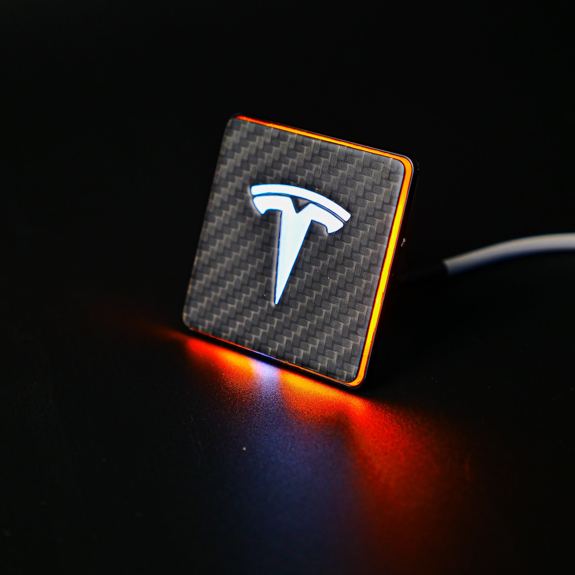 Carbon metal LED-illuminated seat emblems for Tesla Model S, Model 3, Model X, Model Y, and Cybertruck, available in customizable LED colors for front and rear seats.