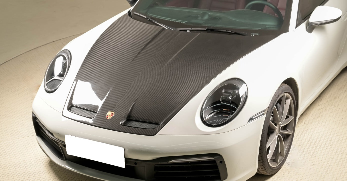 GT3 carbon fiber hood installed on white Porsche 911 992 showing functional air vents and racing design