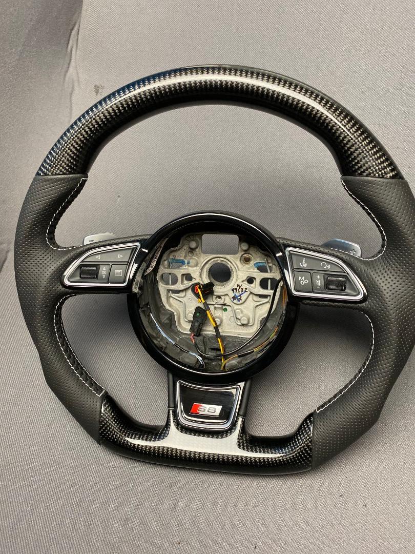 OEM remanufactured Audi S8 steering wheel with carbon fiber, perforated black leather, flat bottom, and piano black center from Custom Class.